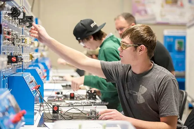 students working on a circuit board students working on a circuit board